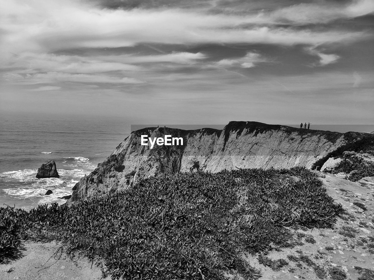 Rock formations by sea against sky