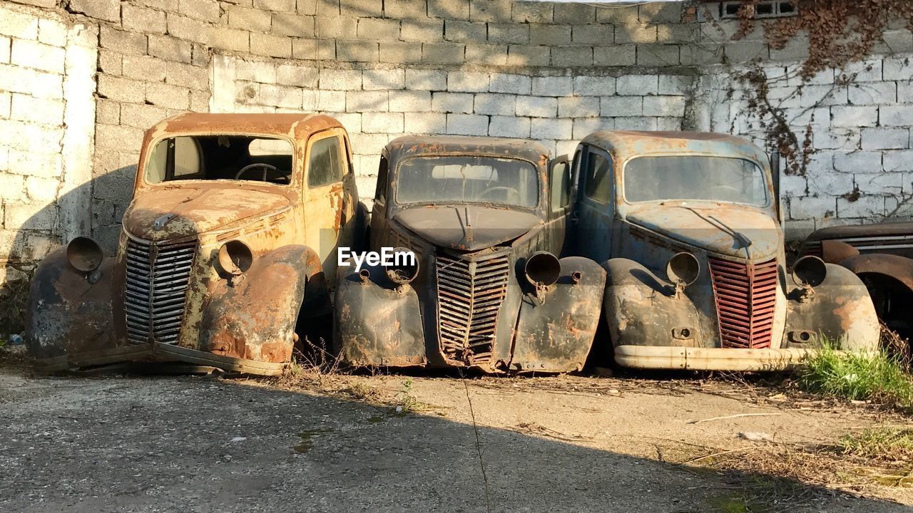 Old abandoned vintage cars against wall