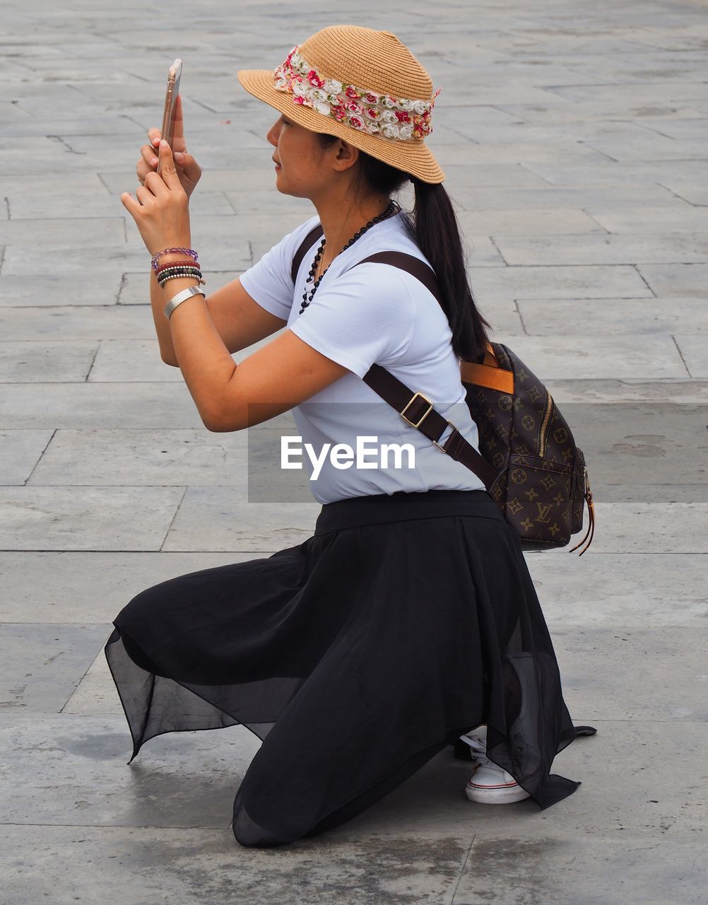 SIDE VIEW OF WOMAN WEARING HAT HOLDING UMBRELLA