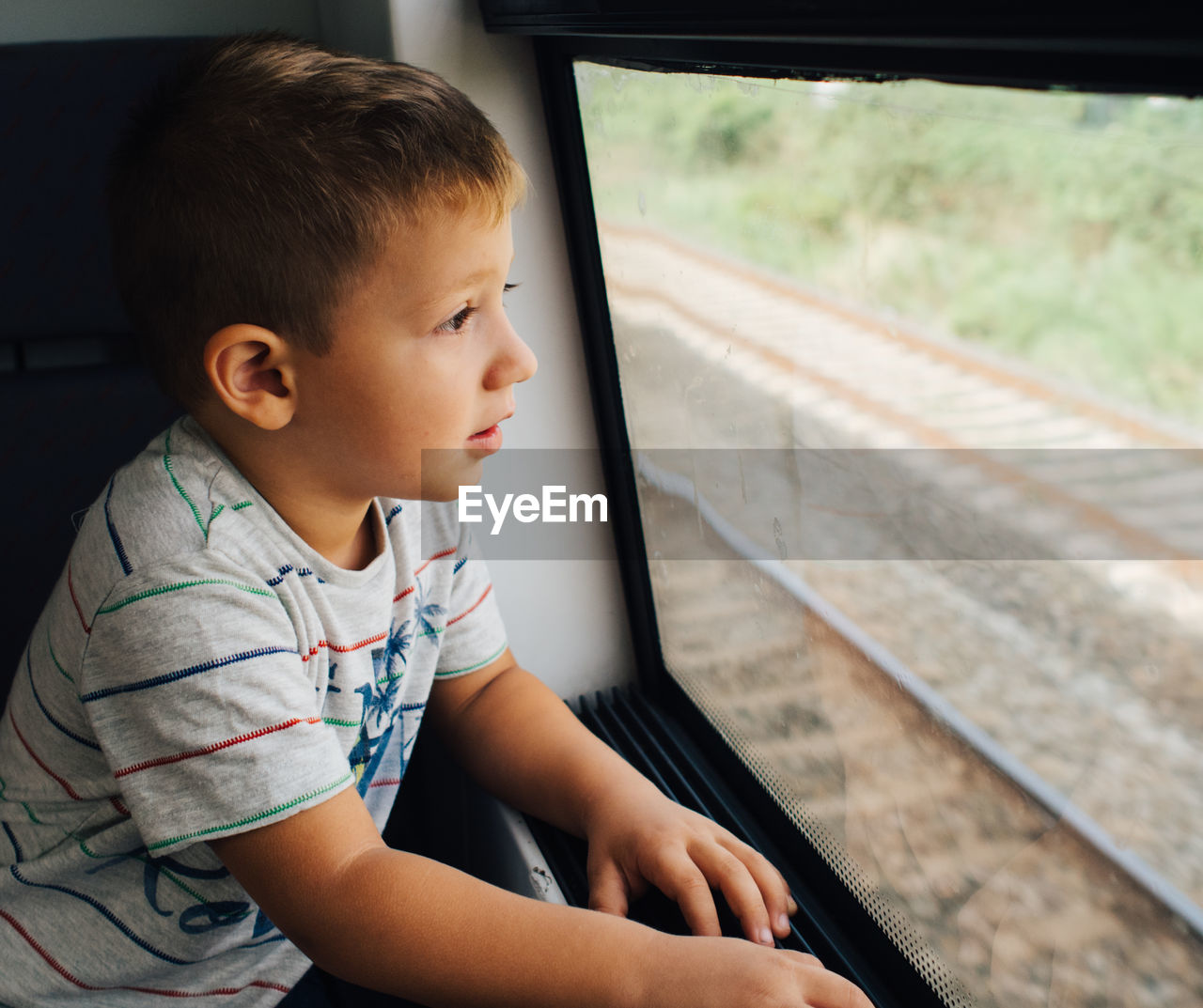 Boy looking through the train window excited about the trip person