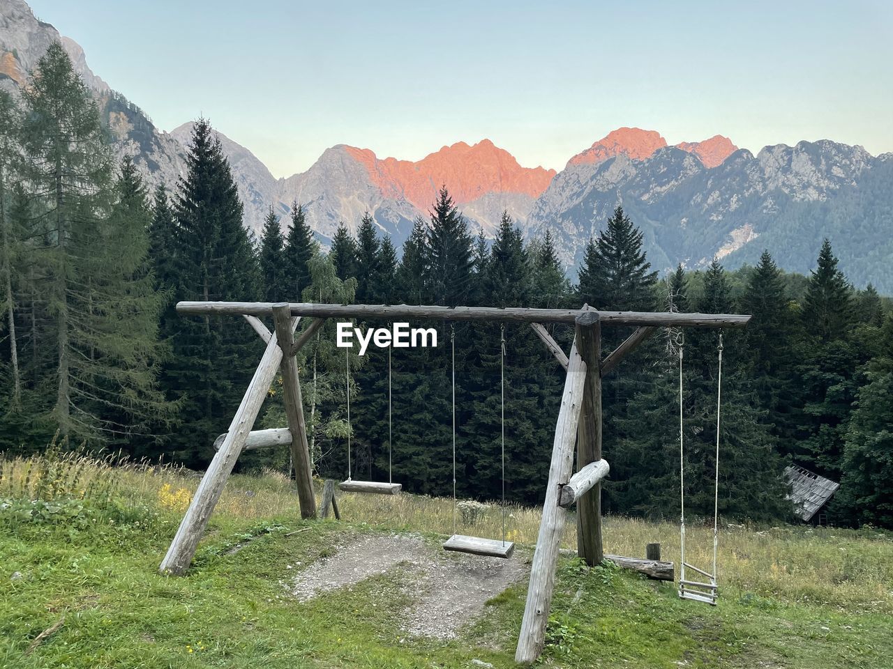 VIEW OF TREES ON FIELD AGAINST MOUNTAINS