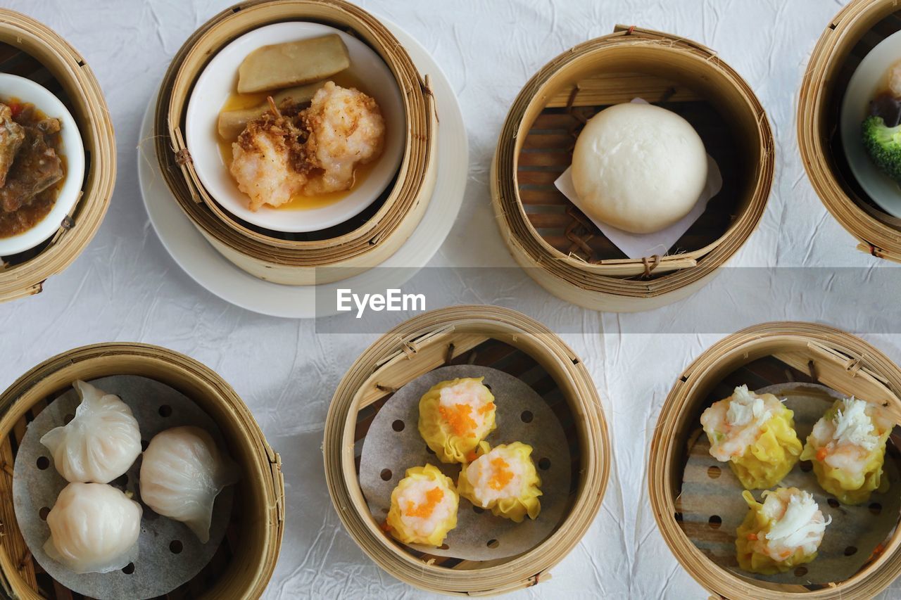 food and drink, dim sum, food, dumpling, chinese dumpling, freshness, asian food, steamed, dish, healthy eating, chinese food, wellbeing, cuisine, no people, container, still life, high angle view, xiaolongbao, meal, indoors, directly above, produce, bamboo - material, shumai, bowl, table, vegetable, appetizer