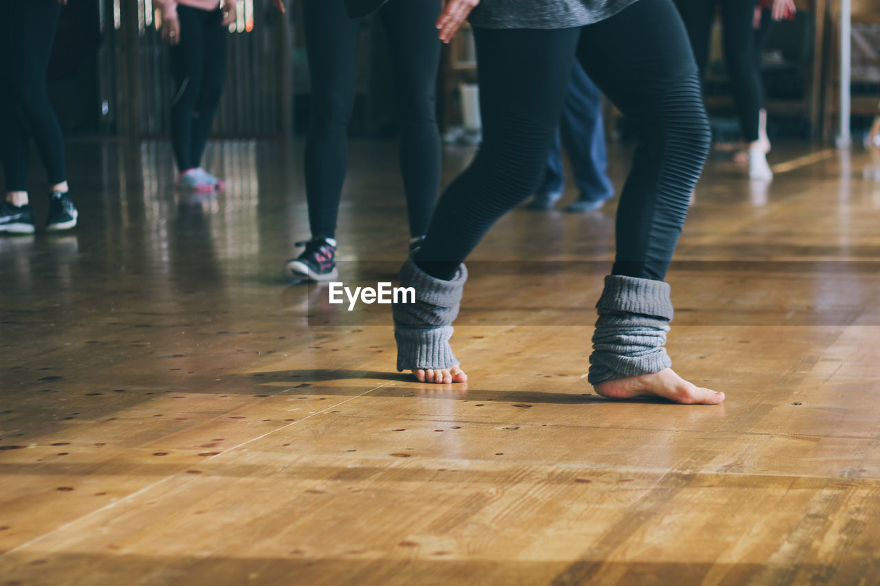 Low section of woman standing on hardwood floor