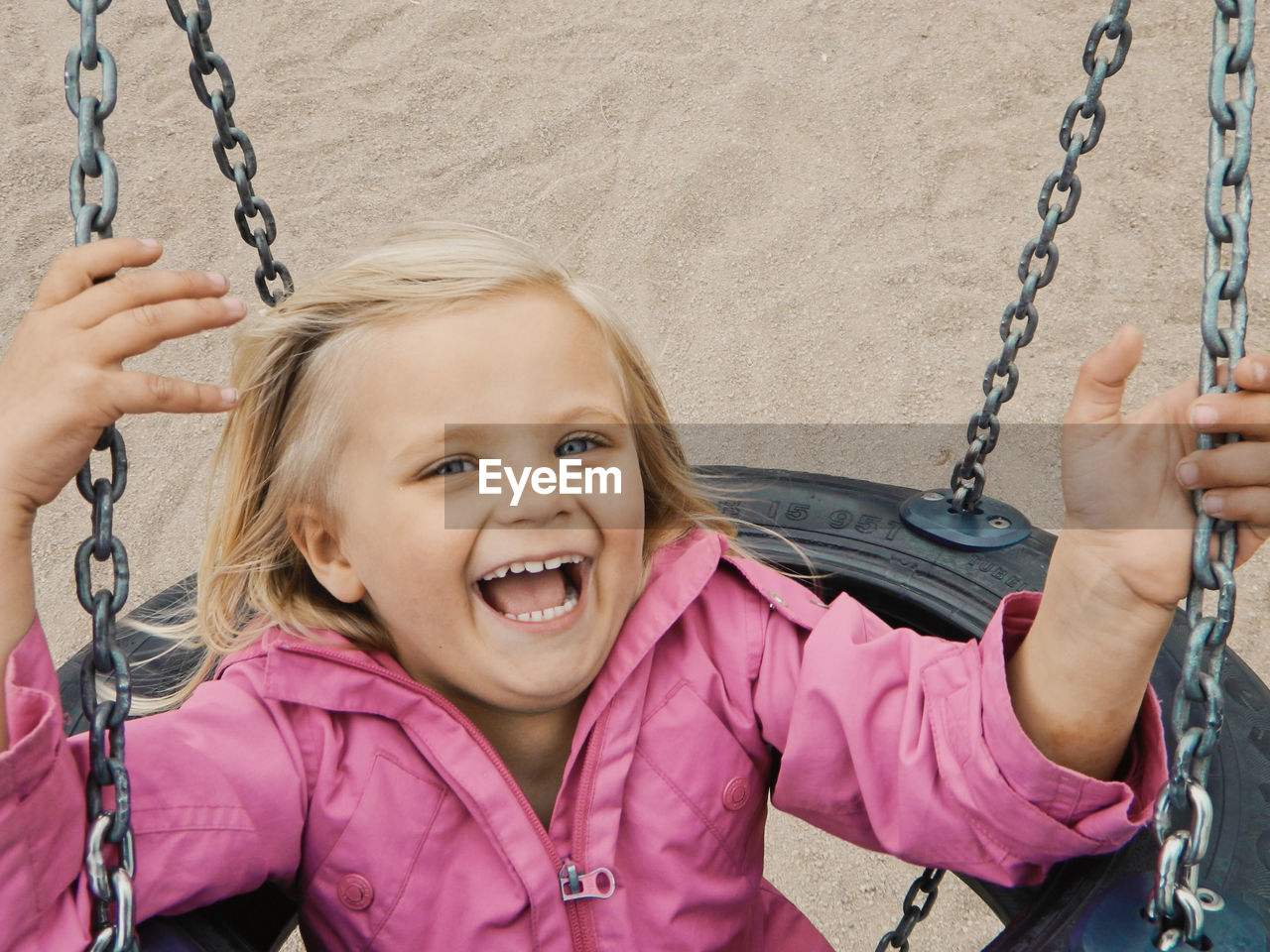 Portrait of a smiling girl on swing