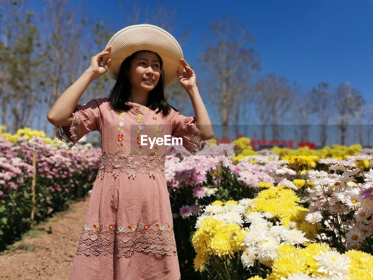 Young woman standing by flowering plants