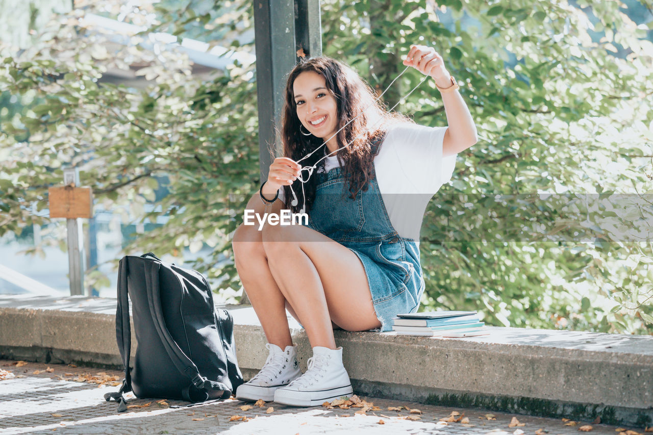 young woman sitting on bench at park