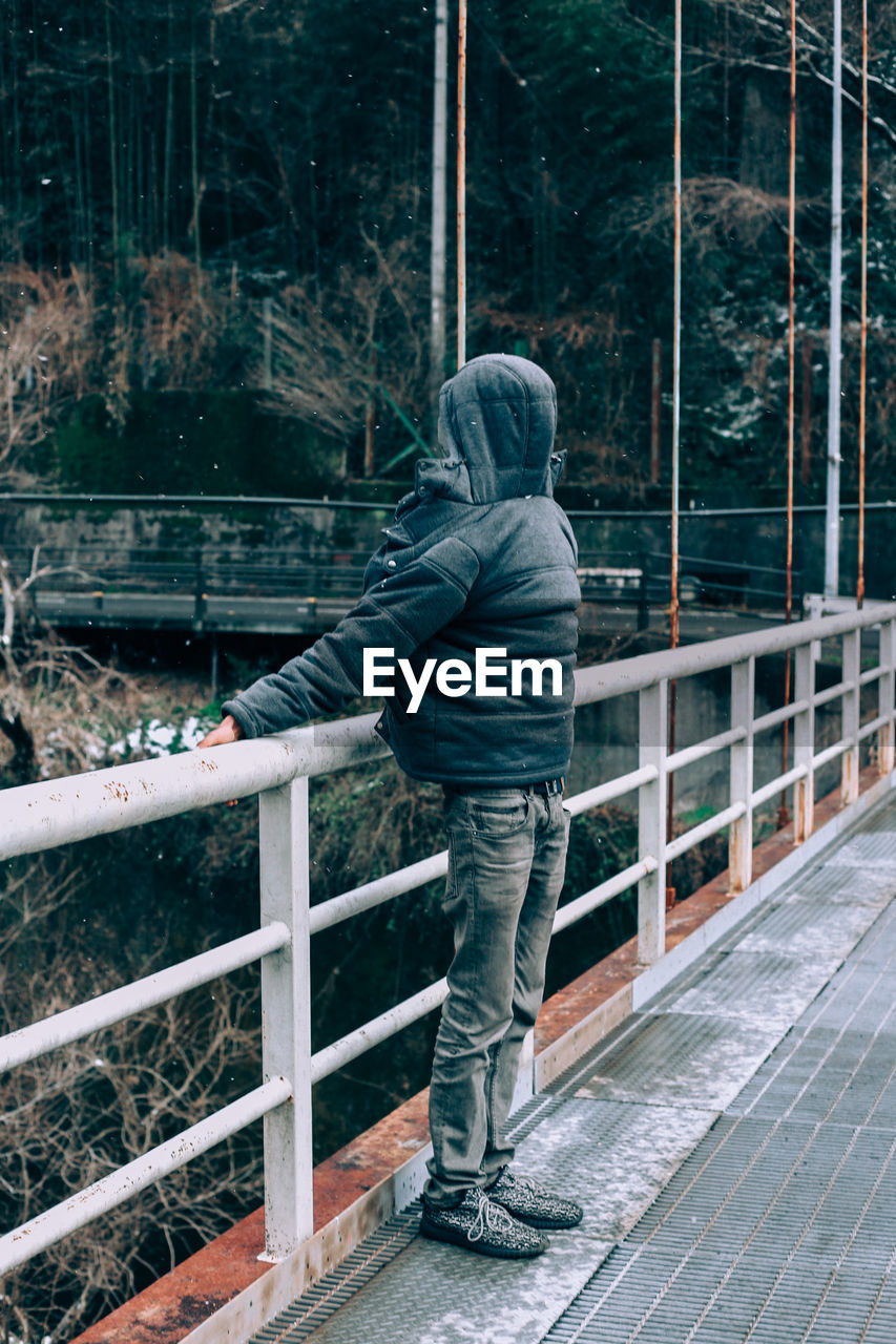 Man standing on bridge