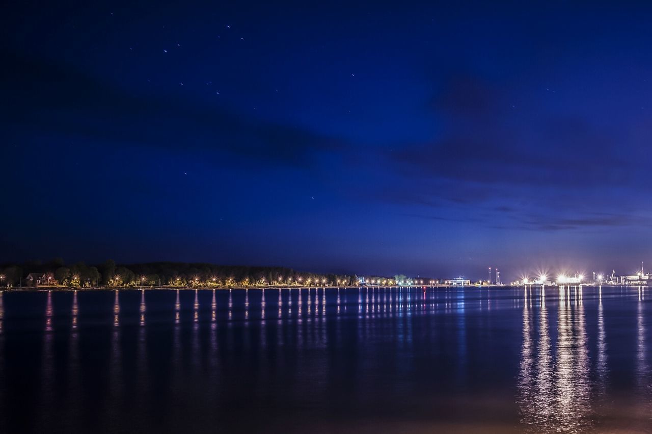 Scenic view of lake against blue sky at night