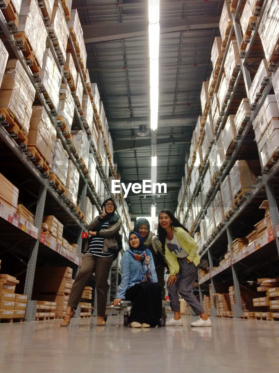 Low angle portrait of happy friends posing in warehouse