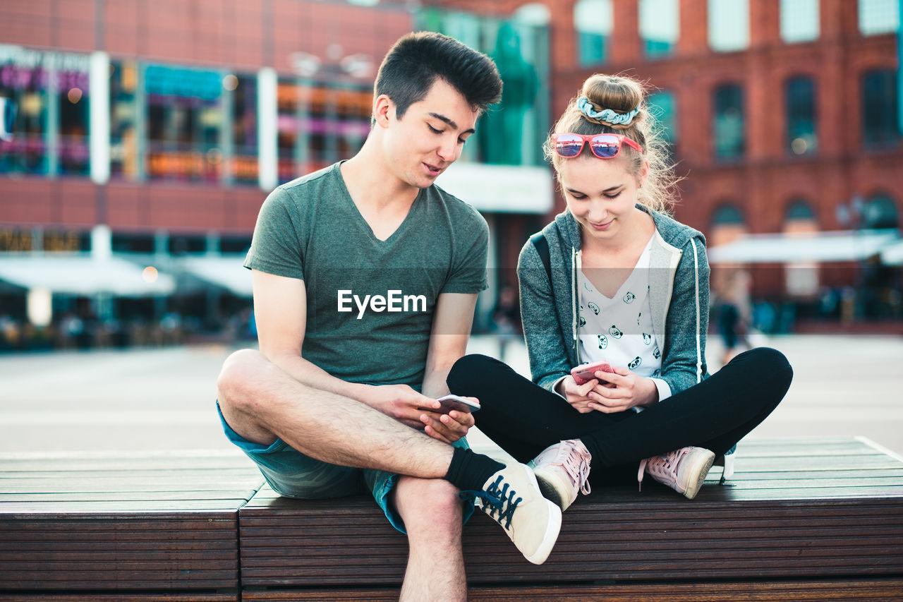 YOUNG COUPLE SITTING IN PARK