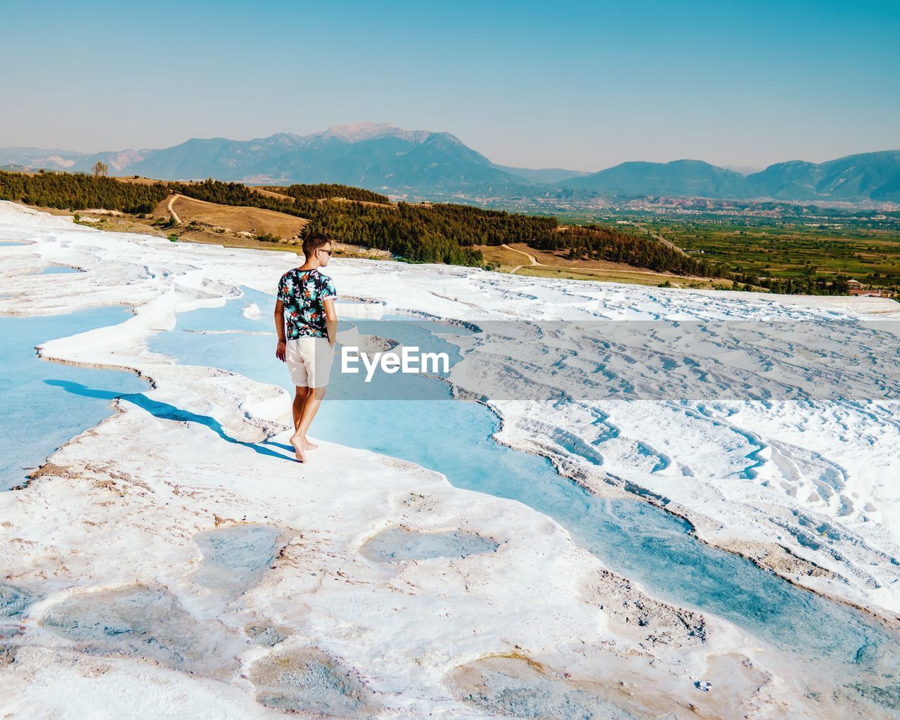 Man walking on snowy land against sky