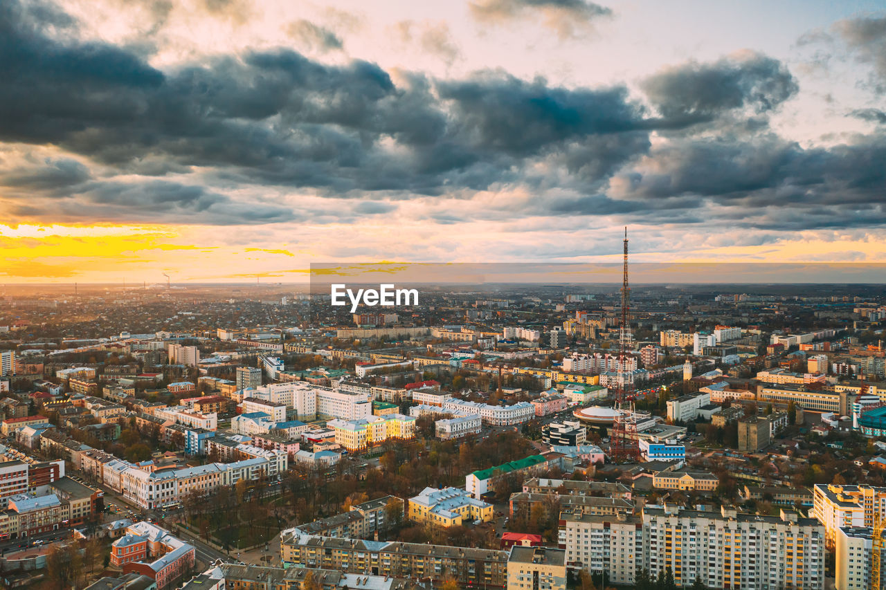 high angle view of townscape against cloudy sky during sunset