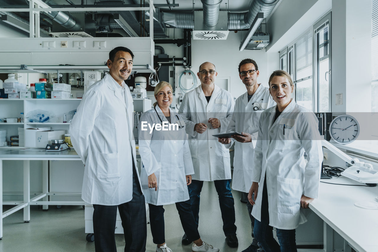 Confident scientist team standing together at laboratory