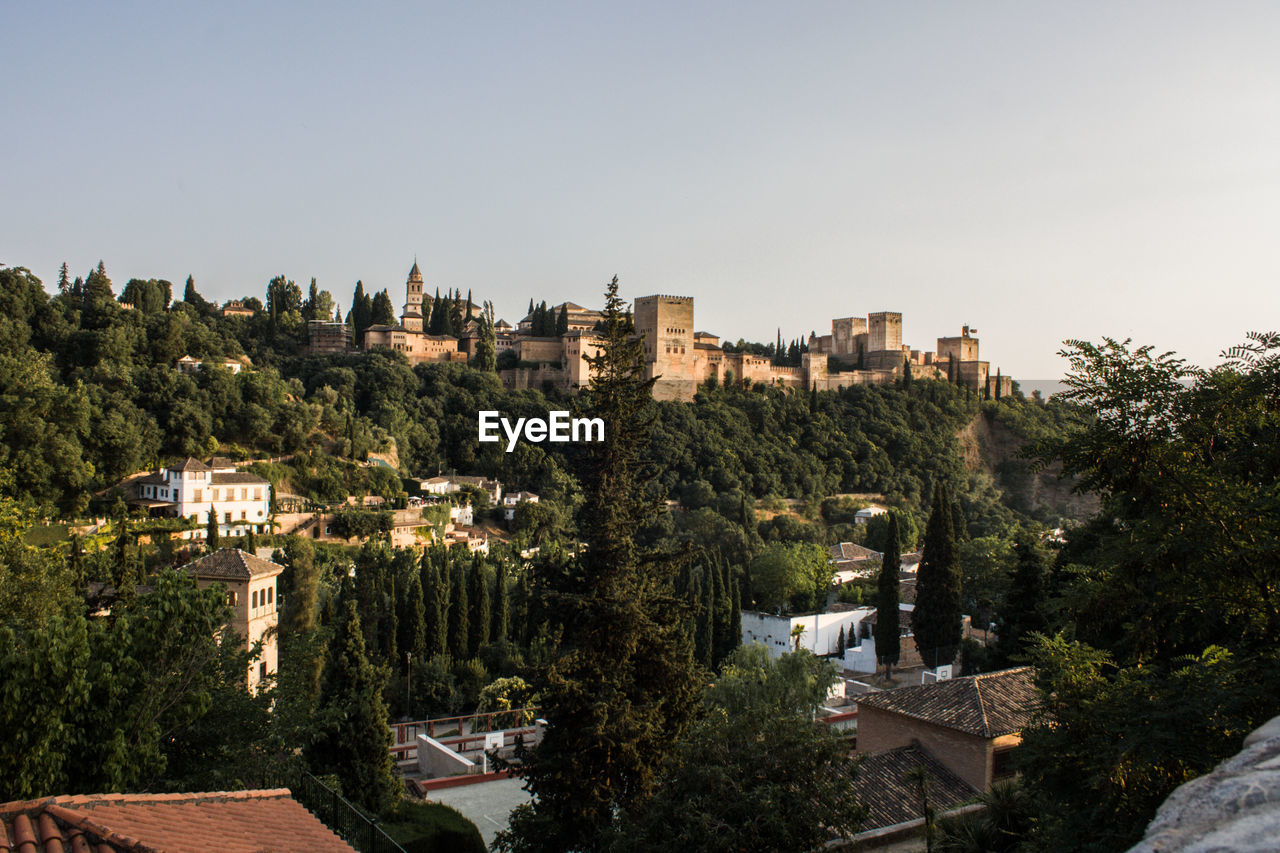 High angle view of trees and buildings against clear sky