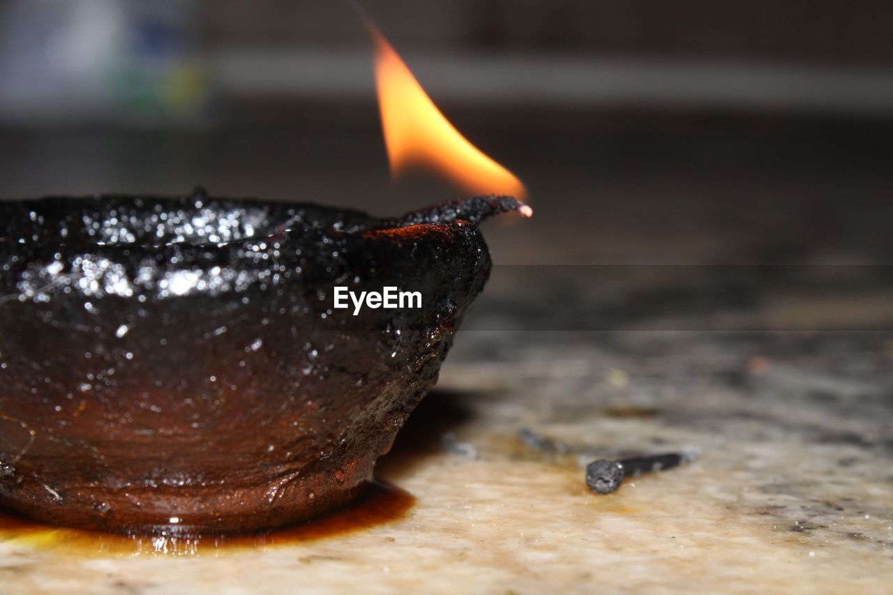 CLOSE-UP OF BURNING CANDLE IN THE DARK