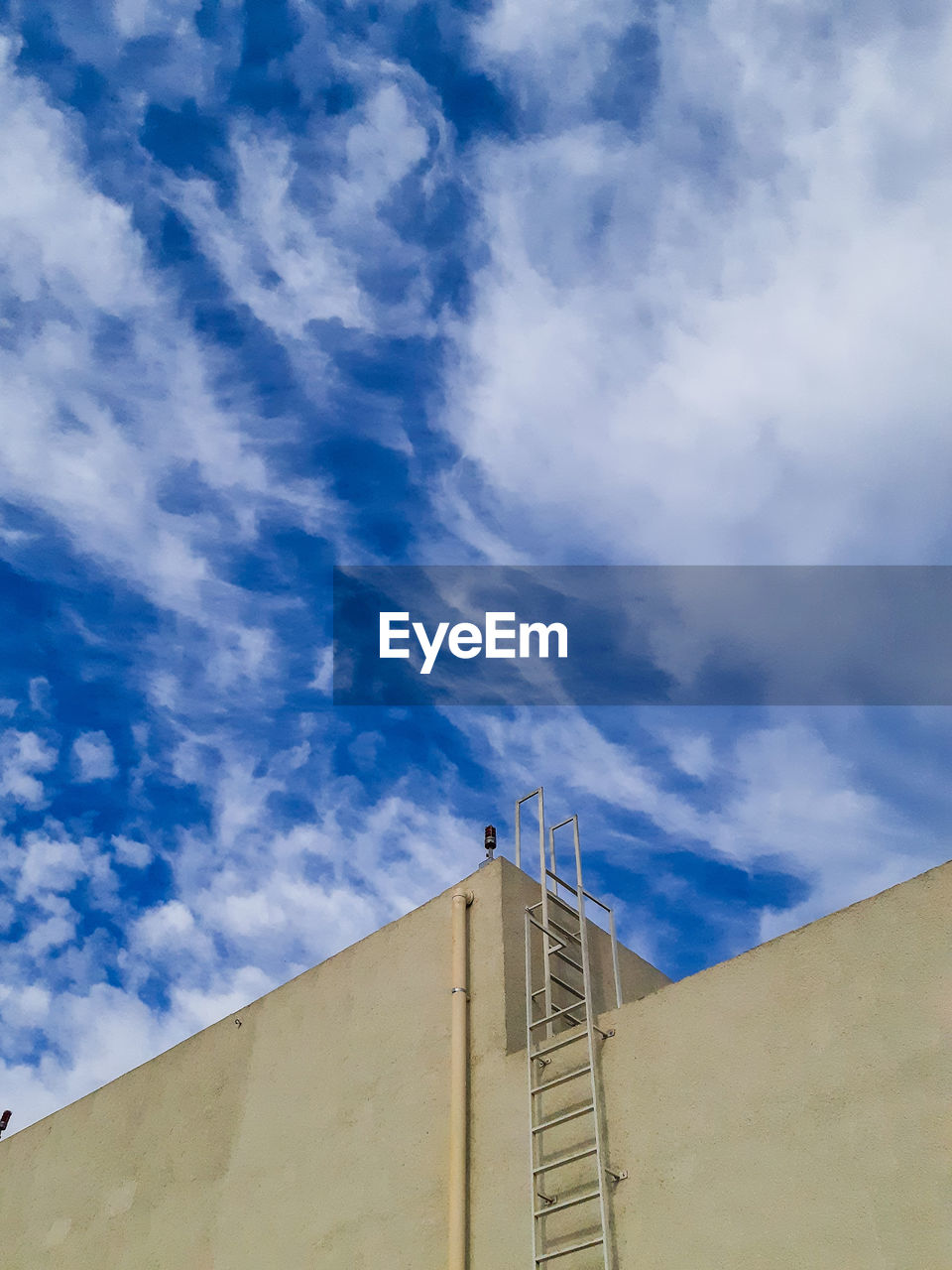 Low angle view of building against cloudy sky