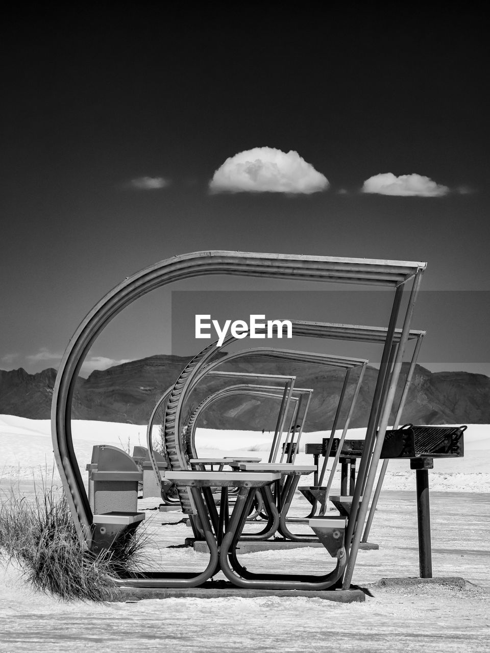 EMPTY CHAIRS AND TABLE ON BEACH