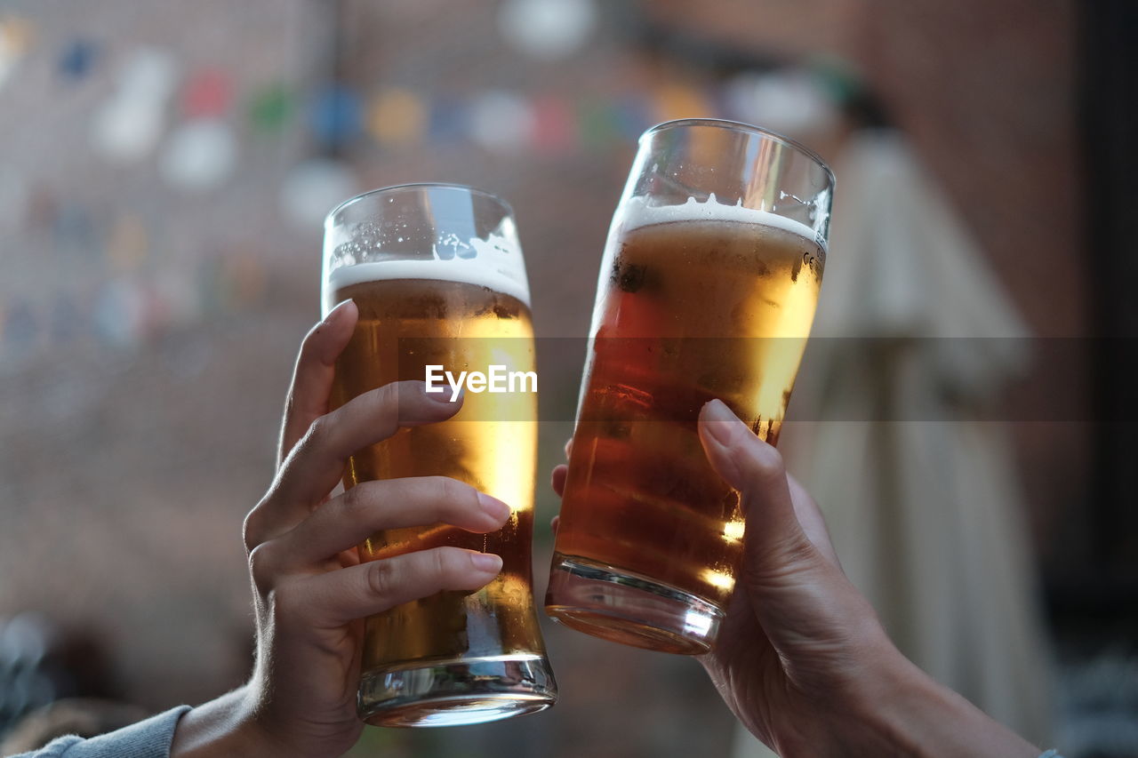 Close-up of hands holding beer glasses