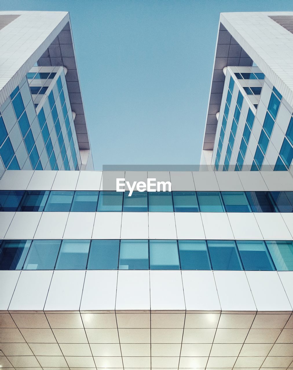 Low angle view of modern building against clear blue sky