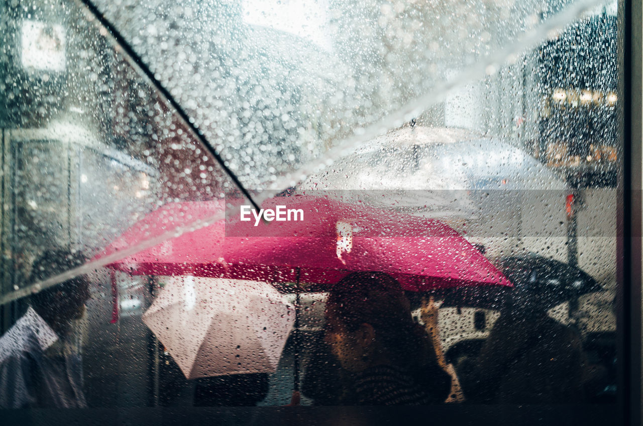 People seen through wet window during rain