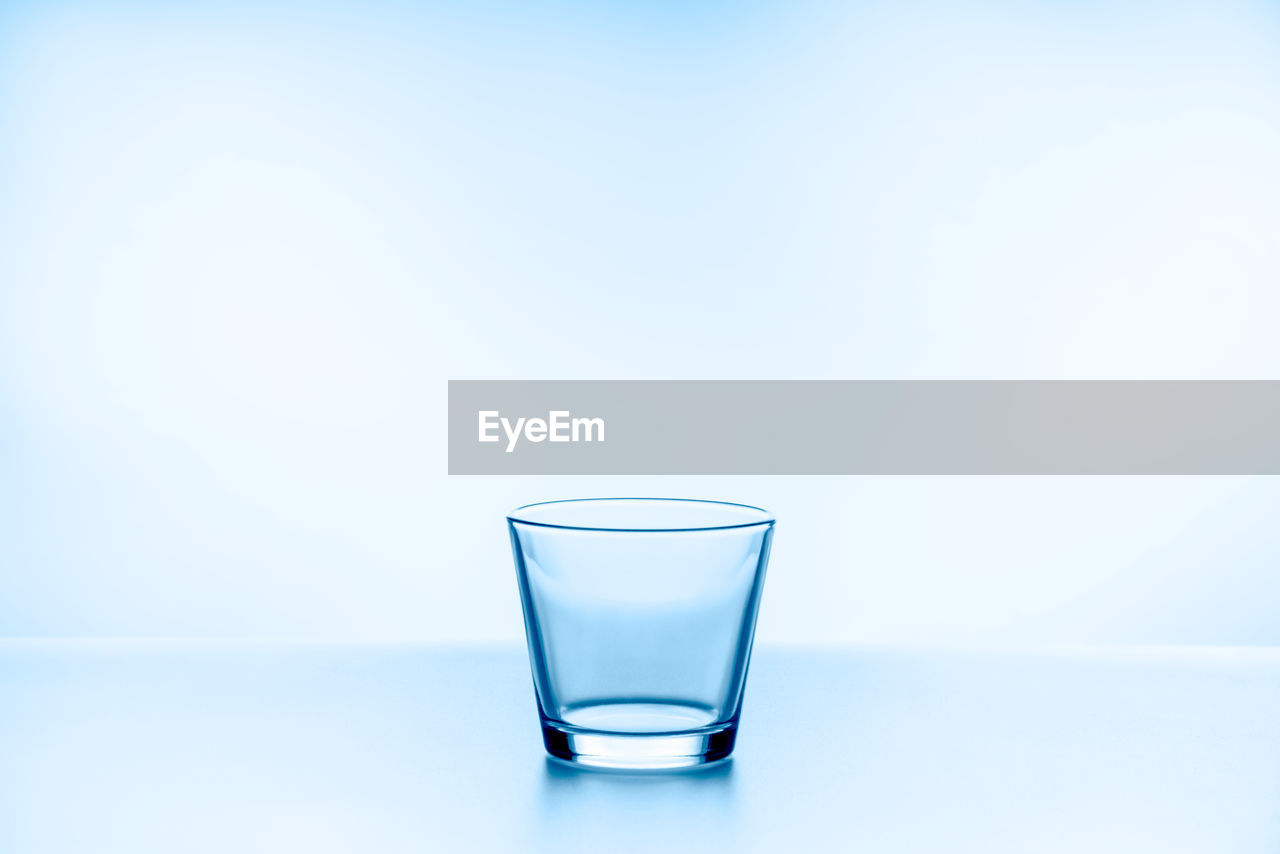 CLOSE-UP OF DRINK IN GLASS AGAINST BLUE BACKGROUND