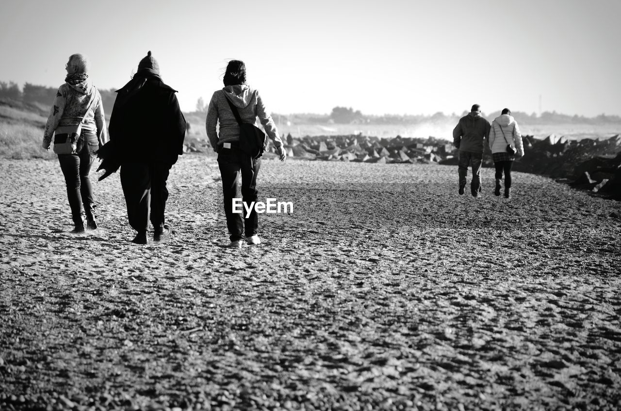 Rear view of people walking on beach