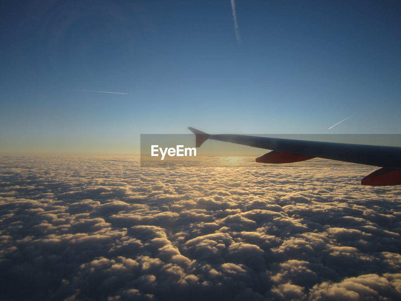 Cropped image of airplane flying over cloudscape