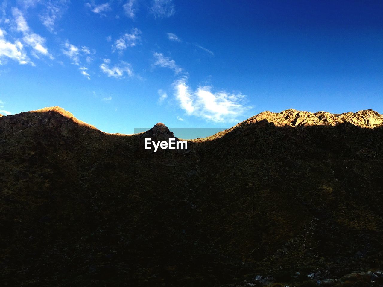 Scenic view of mountains against blue sky