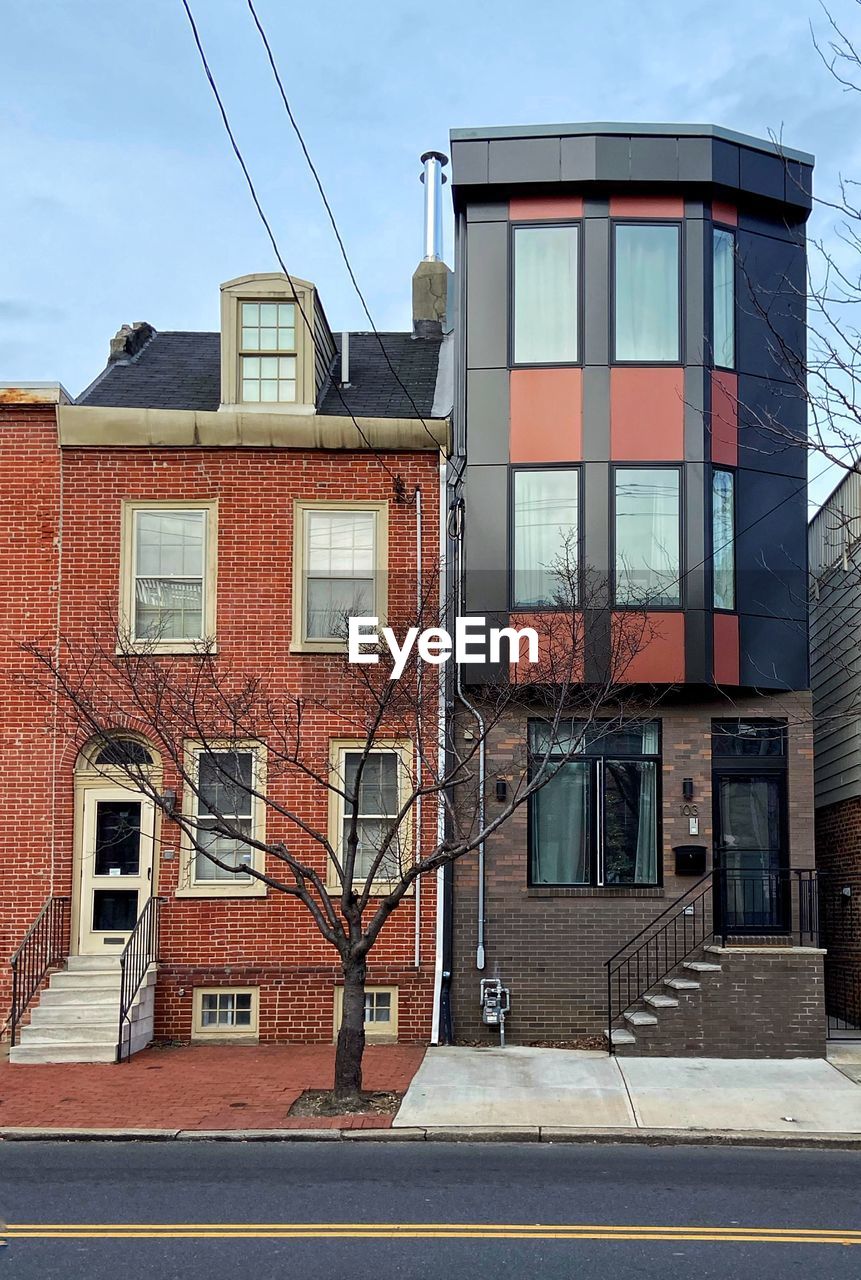 LOW ANGLE VIEW OF BUILDINGS BY STREET AGAINST SKY