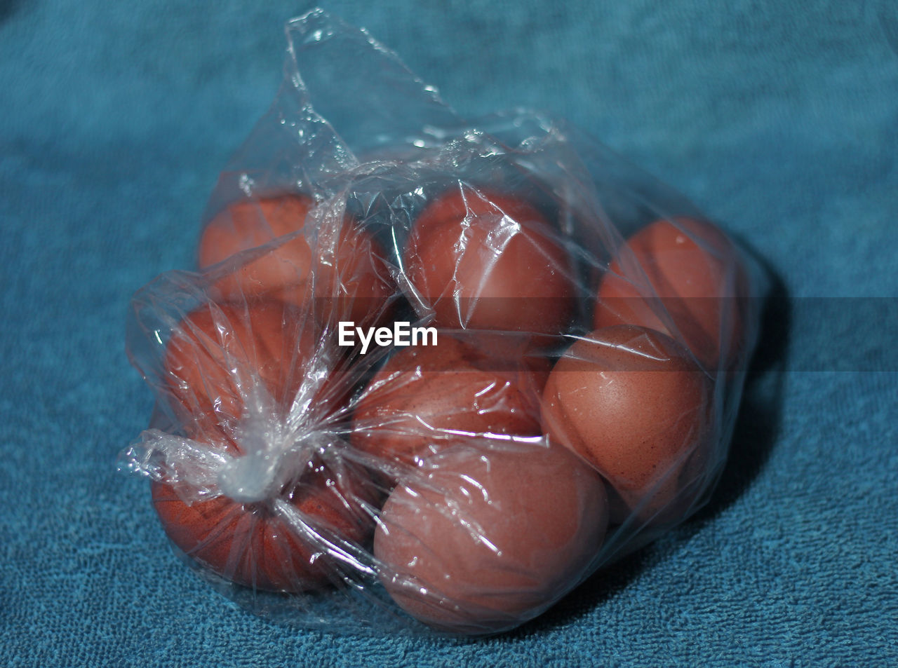 HIGH ANGLE VIEW OF LEMON IN PLASTIC ON TABLE