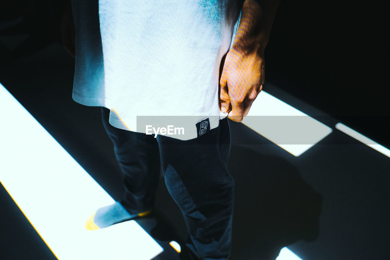 CLOSE-UP LOW SECTION OF MAN STANDING ON FLOOR