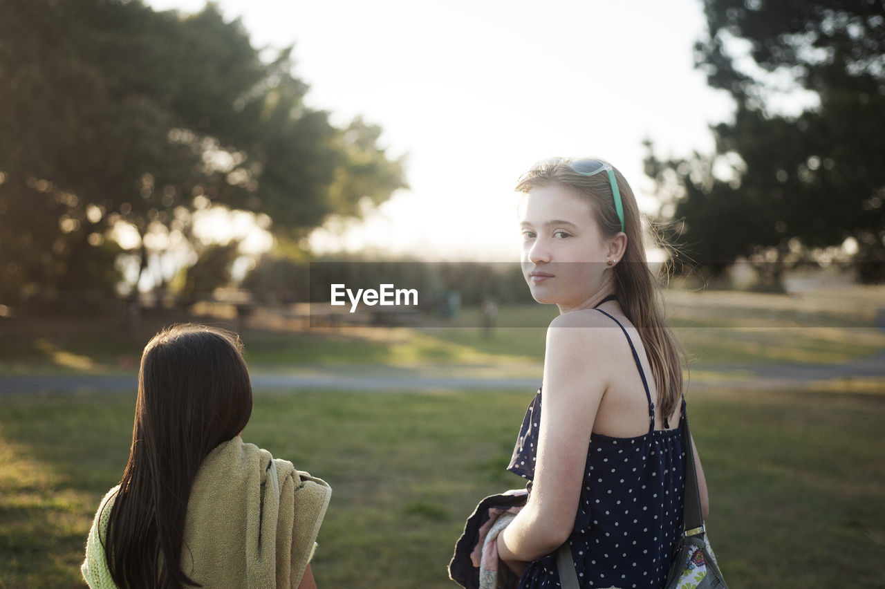 Portrait of girl walking with sister on field