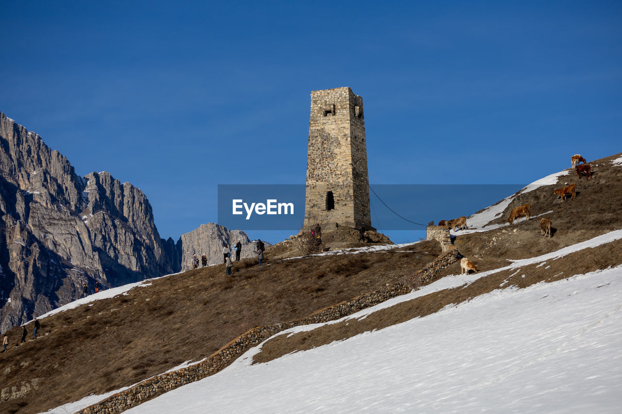 Scenic view of snowcapped mountains against clear blue sky