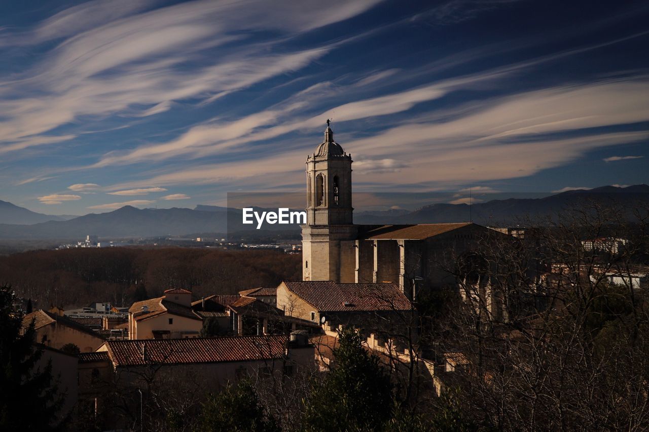 HIGH ANGLE VIEW OF BUILDINGS IN TOWN AGAINST SKY AT SUNSET