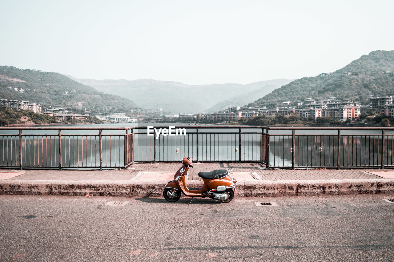 MOTORCYCLE ON ROAD AGAINST MOUNTAINS