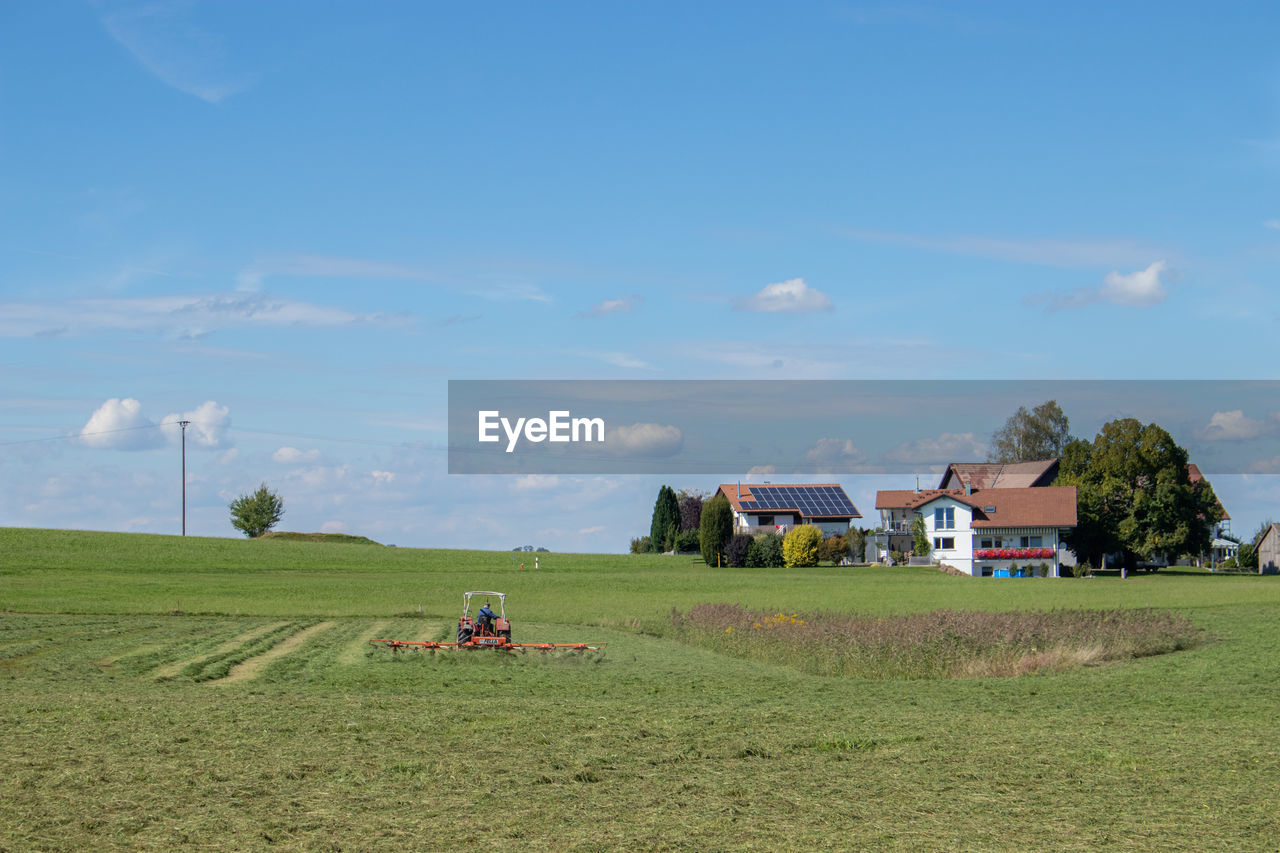 PEOPLE ON AGRICULTURAL FIELD AGAINST SKY