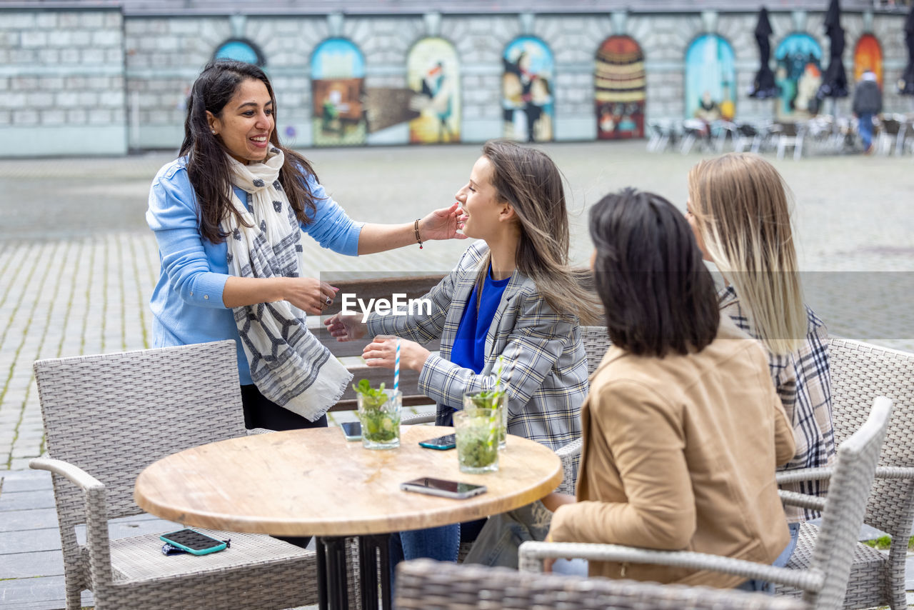 side view of friends using digital tablet in restaurant