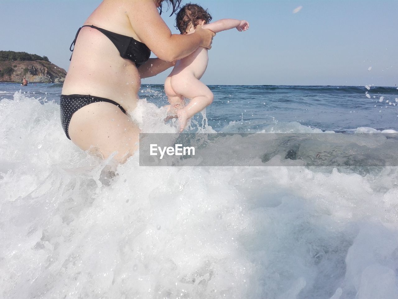 FULL LENGTH OF WOMAN SPLASHING WATER IN SEA