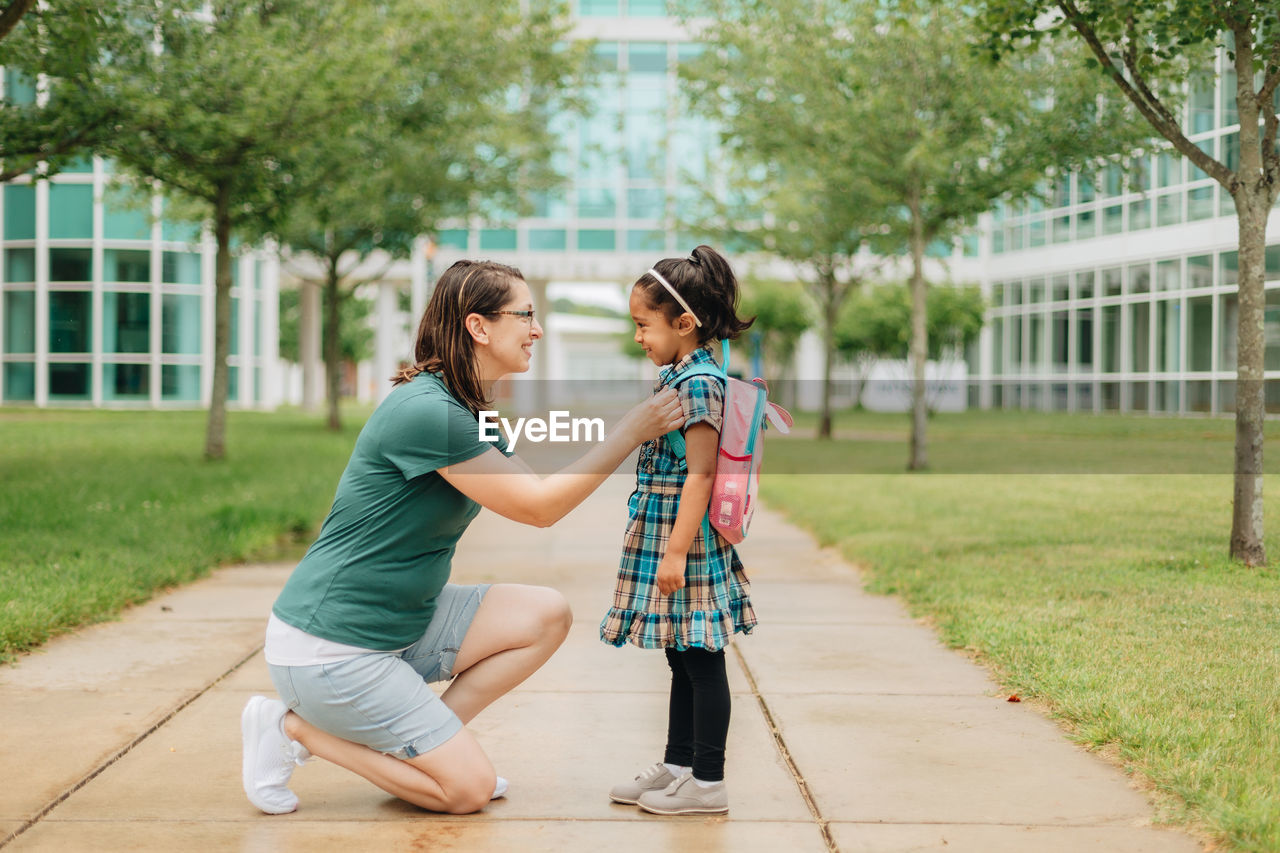 Young millennial mother sending daughter off back to school