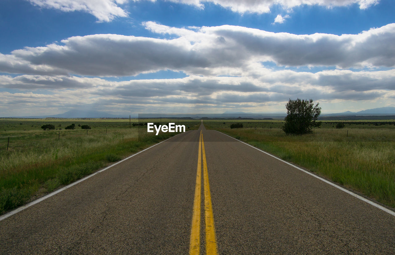 Road by landscape against sky