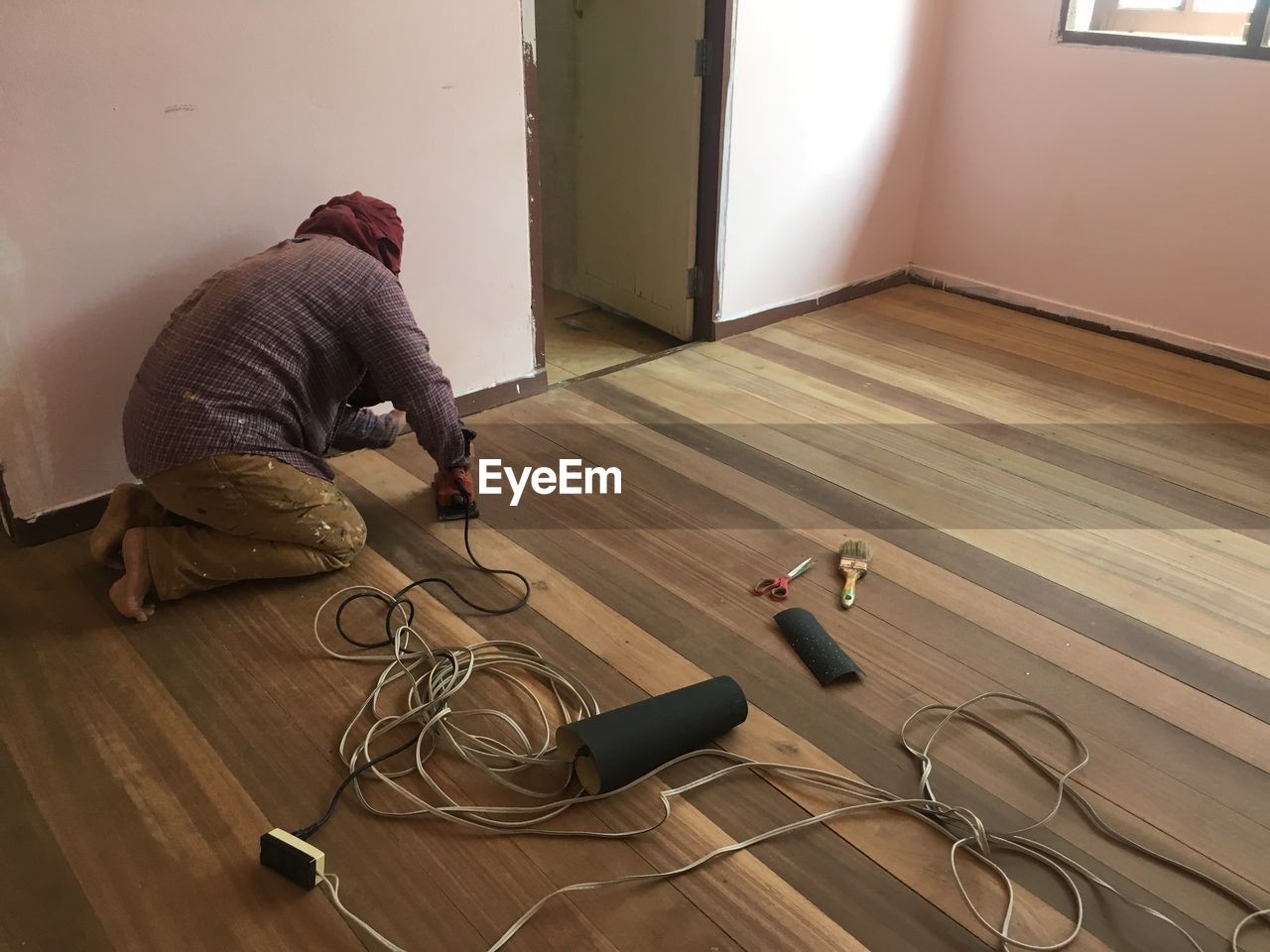 Worker working on wooden floor at home