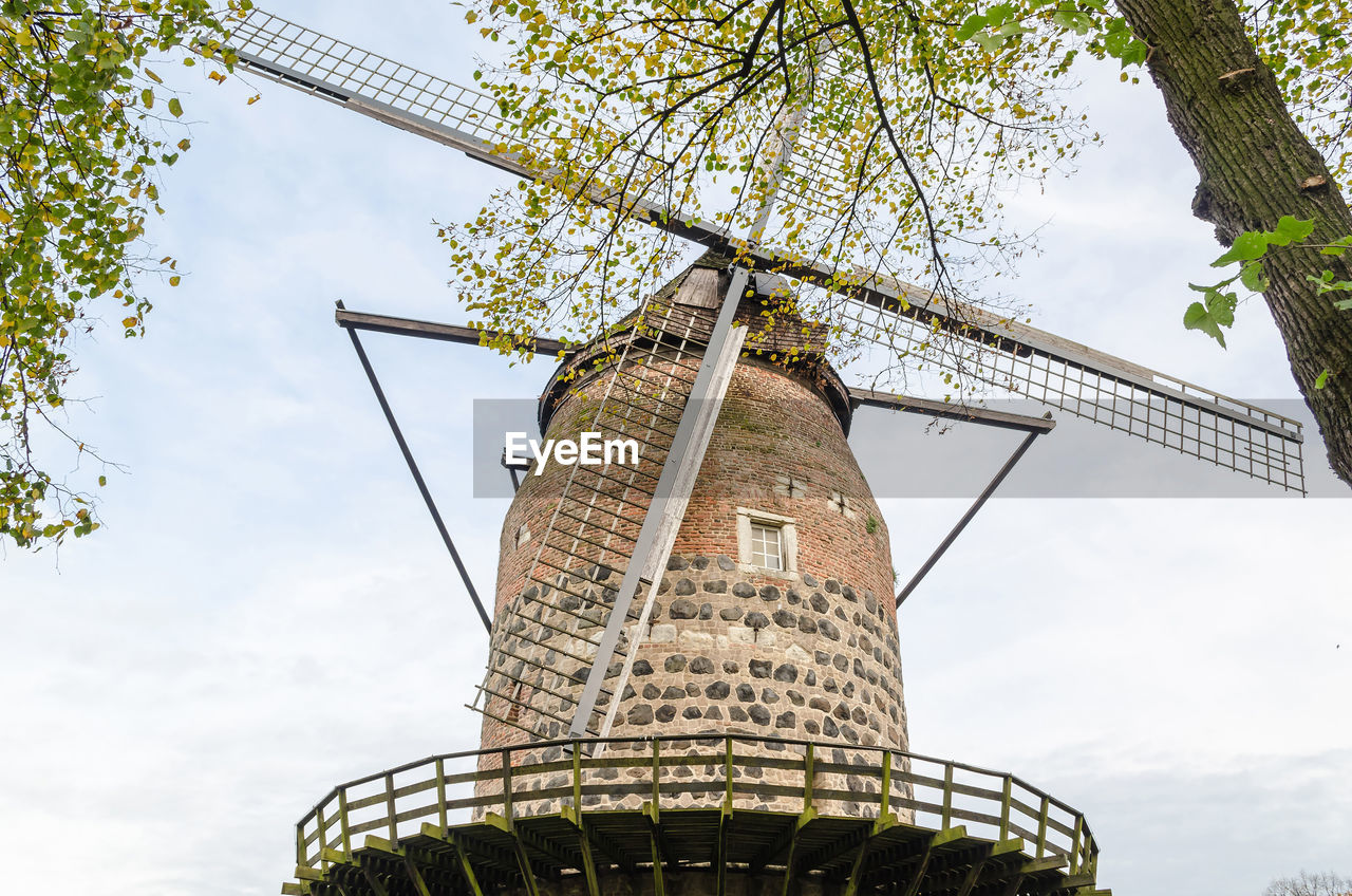 Low angle view of traditional windmill against sky