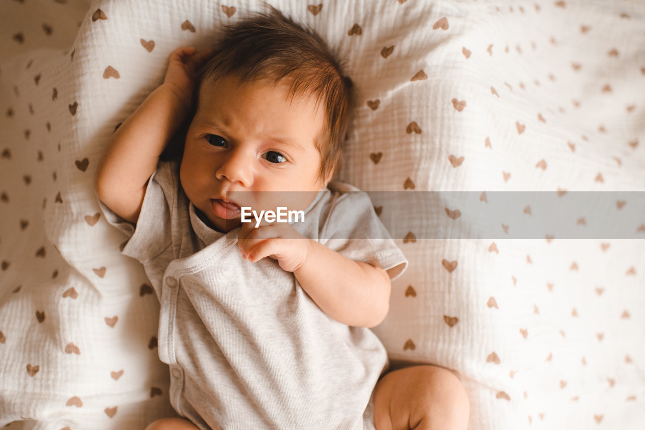 high angle view of cute baby girl lying on bed at home