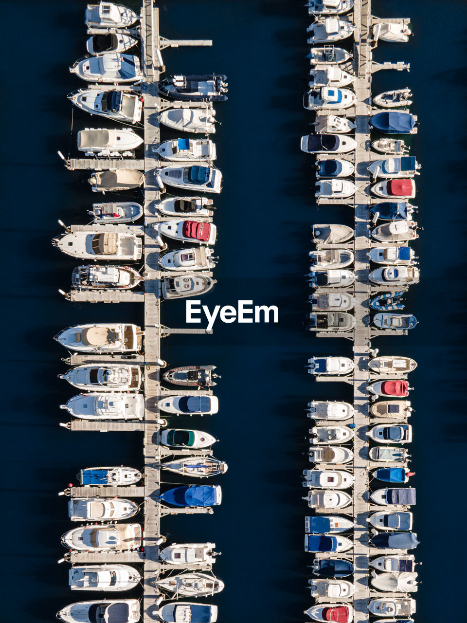 Aerial view of sailboats moored in sea against buildings in city