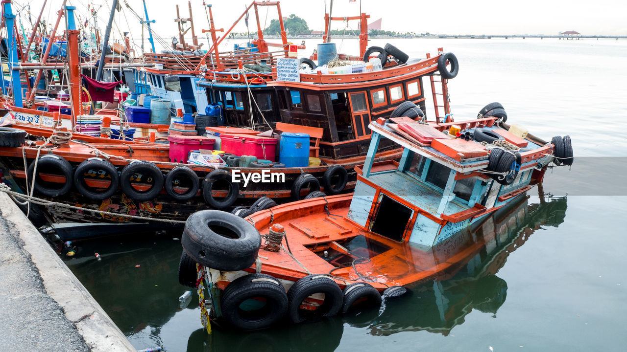 High angle view of fishing boat sinking in sea at harbor