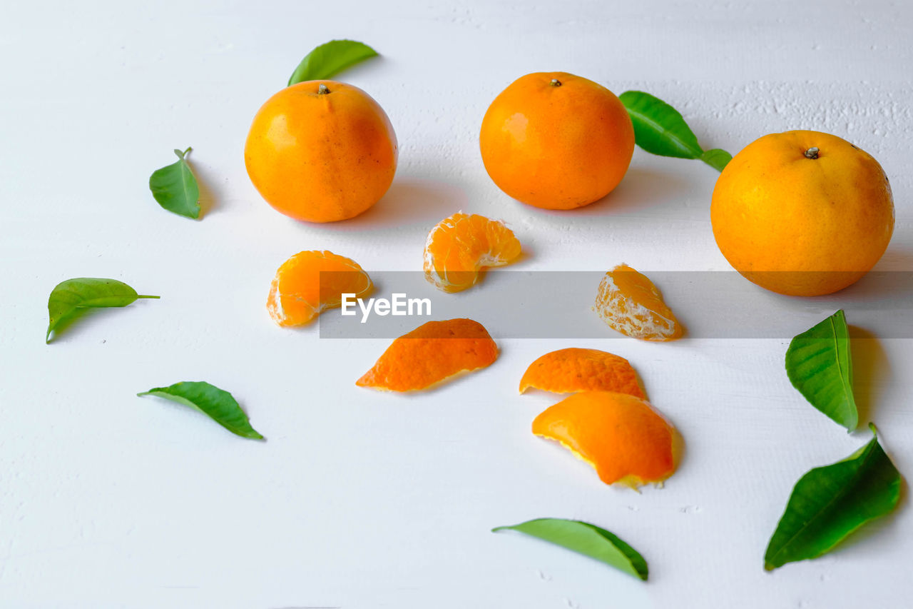 food and drink, food, healthy eating, plant, freshness, fruit, wellbeing, orange color, produce, leaf, citrus, plant part, citrus fruit, tangerine, orange, clementine, no people, studio shot, indoors, nature, still life, group of objects, high angle view