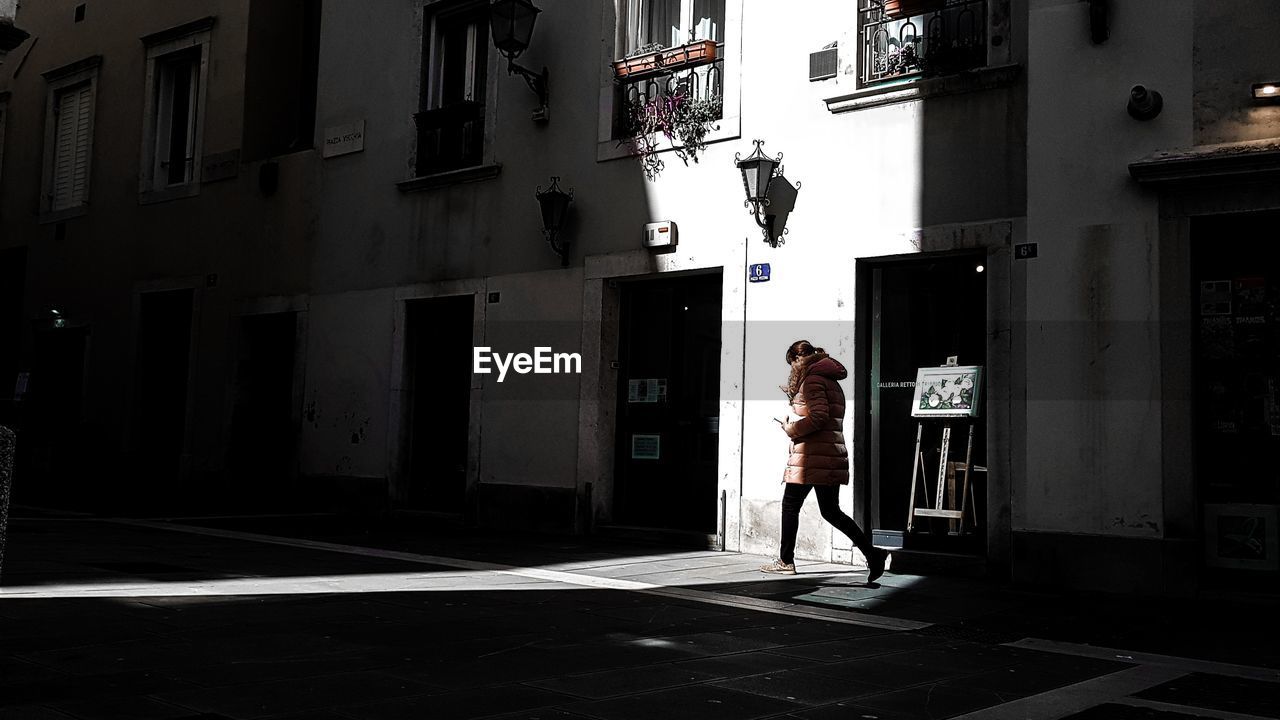 WOMAN WALKING ON STREET IN CITY