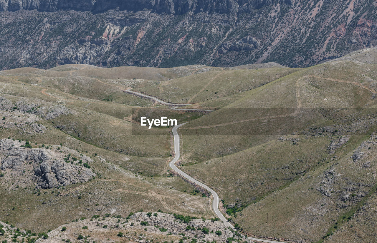 HIGH ANGLE VIEW OF WINDING ROAD ON MOUNTAIN