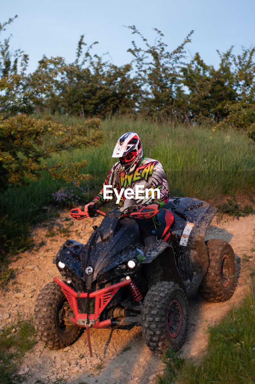 MAN RIDING BICYCLE ON DIRT ROAD