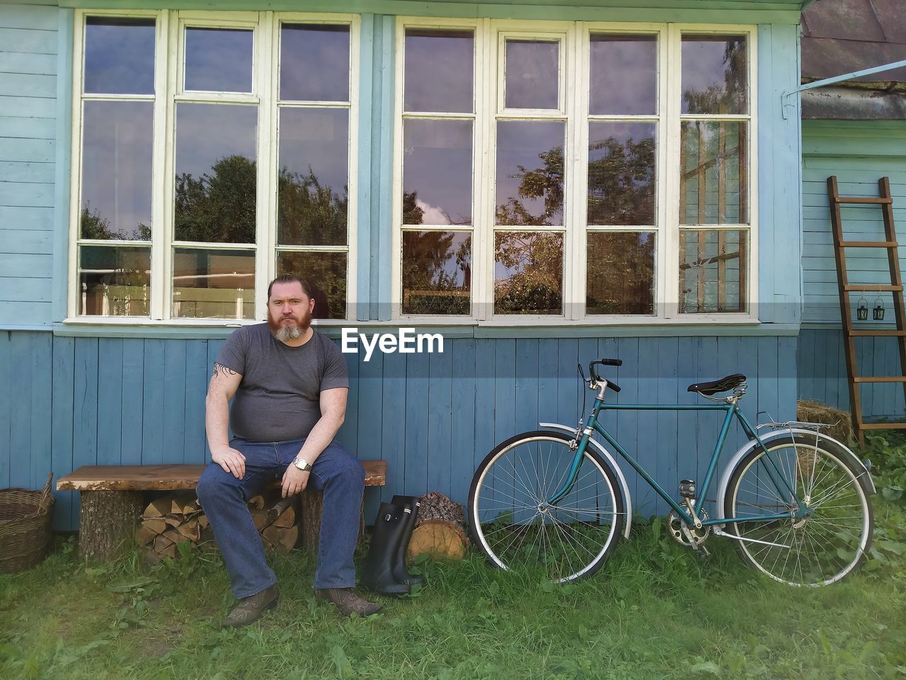 Portrait of man with bicycle against plants